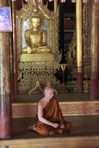 Mnich, siedzący obok posągu Buddy, skaczący kot klasztor, inle lake, shan Państwa, myanmar, Azji południowo-wschodniej — Zdjęcie stockowe