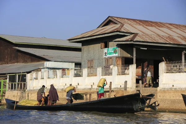Pria Burma membongkar karung dari perahu, danau Inle, negara bagian Shan, Myanmar, Asia Tenggara — Stok Foto