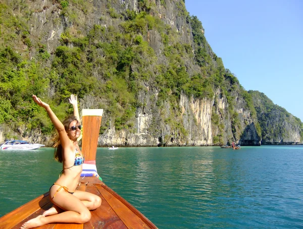 Mujer joven en bikini sentada en una popa de bote de cola larga, isla Phi Phi Lei, Tailandia —  Fotos de Stock