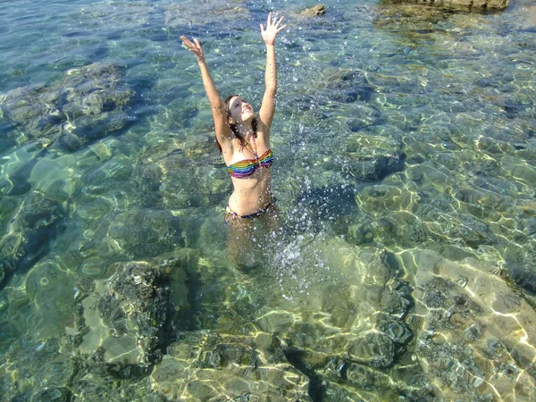 Mujer joven en bikini chapoteando por diversión — Foto de Stock