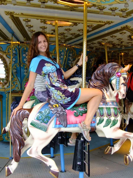 Jonge vrouw op merry-go-round carrousel — Stockfoto