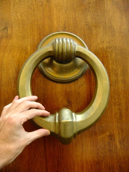 Hand holding doorknocker — Stock Photo, Image