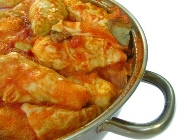 Cabbage rolls in a pan from the side on white background clipart