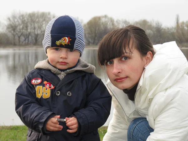 Baby boy and mom on a walk around the lake — Stok Foto