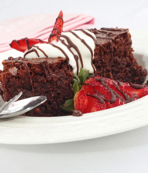 Chocolate brownies with cream and strawberries — Stock Photo, Image
