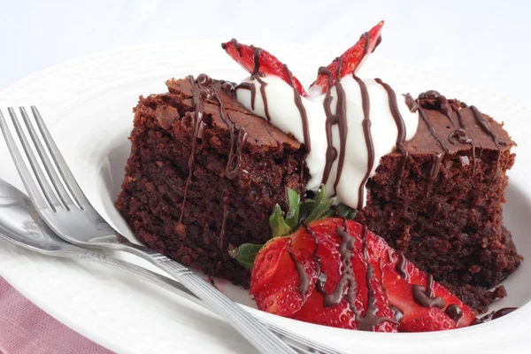 Brownies de chocolate con crema y fresas Imagen de stock