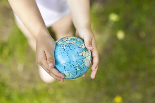 Segurando um globo terrestre nas mãos — Fotografia de Stock