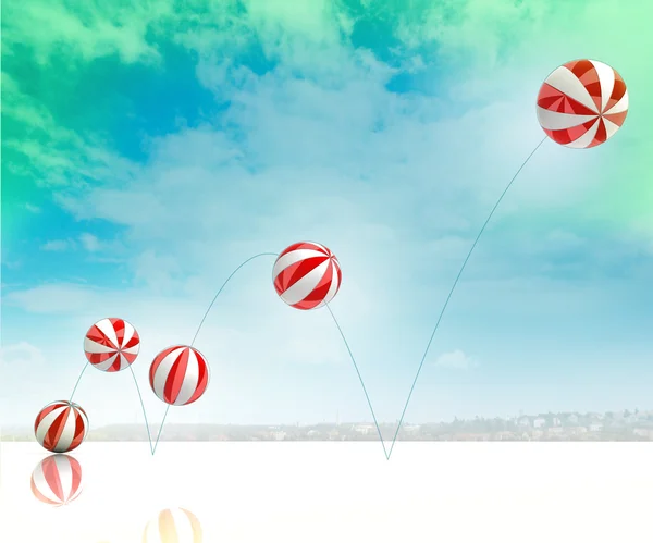 Fünf hüpfende weiß-rot gestreifte aufblasbare Bälle am grün-blau bewölkten Himmel — Stockfoto