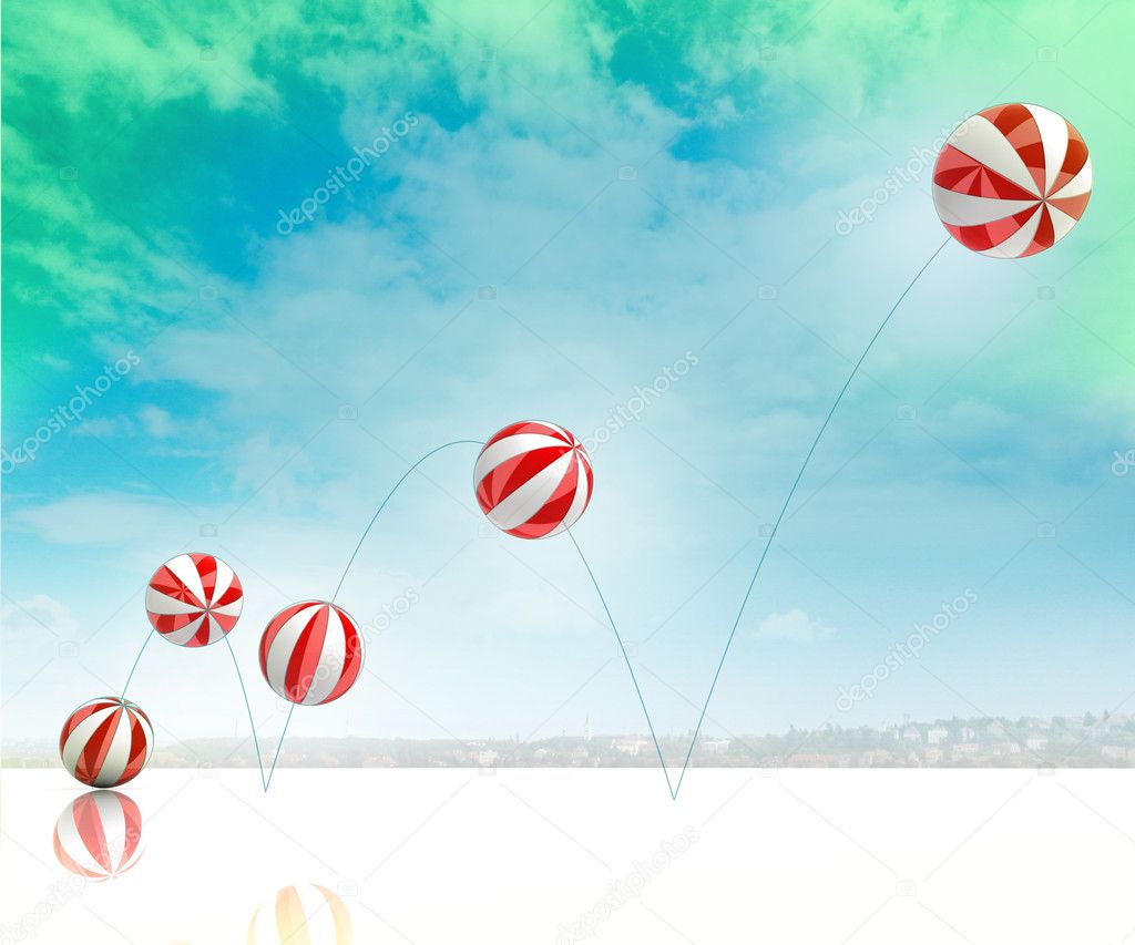 Five jumping white red striped inflatable balls on green blue cloudy sky