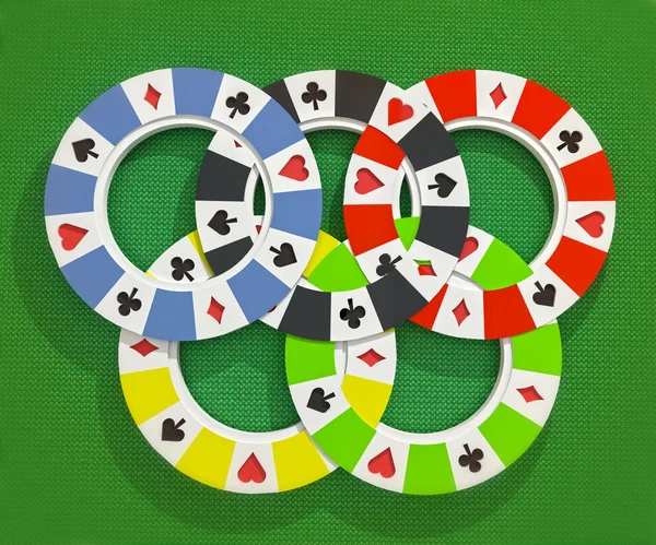 Pięć kolorowych rodzajów pokera chipy olimpijski koła na białym tle na poker stół tło — Zdjęcie stockowe