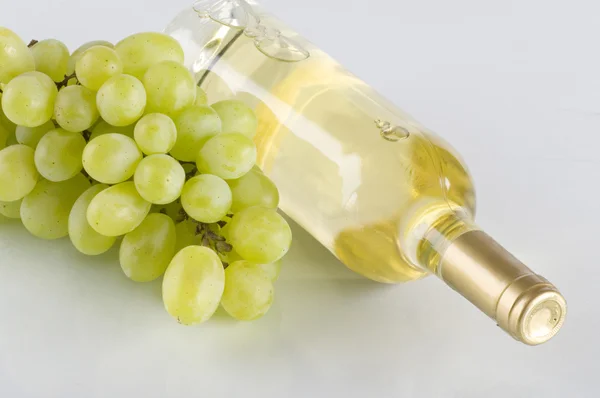 一瓶白葡萄酒和串葡萄 — 图库照片