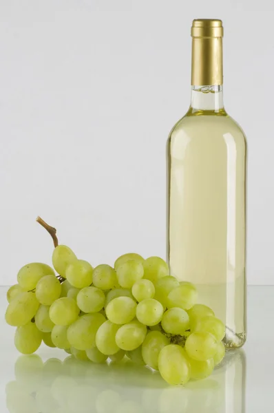 Una bottiglia di vino bianco e grappolo d'uva — Foto Stock