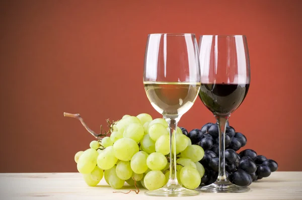 Glasses of red and white vine with grapes — Stock Photo, Image