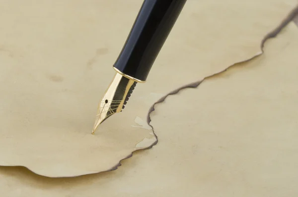 Золотая ручка на бумаге — стоковое фото