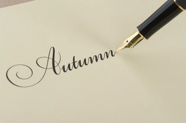 Inscriptie herfst met gouden pen — Stockfoto