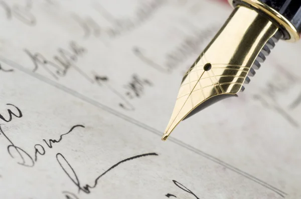 Золотая ручка с ретро-каллиграфией — стоковое фото