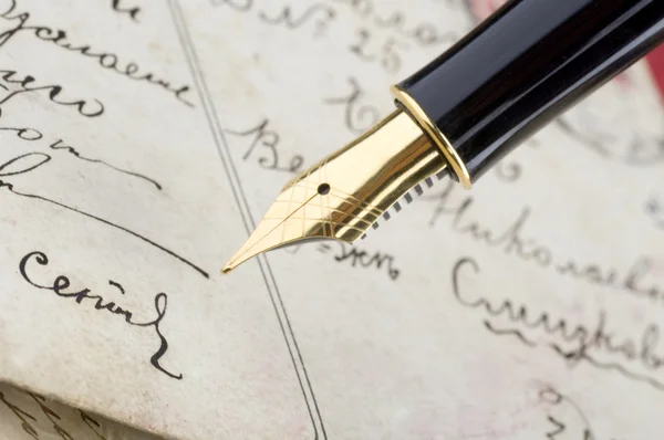 Золота ручка з каліграфією — стокове фото