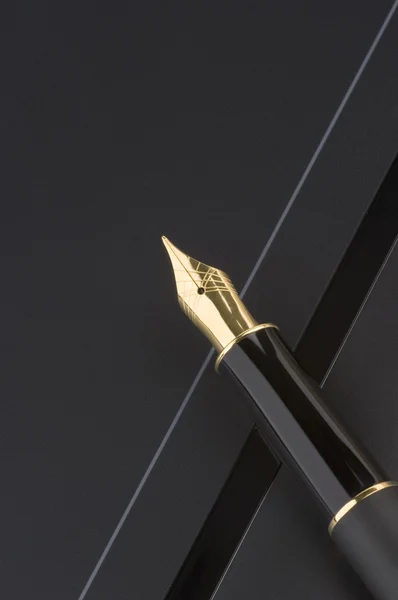 Gouden pen op zwart — Stockfoto