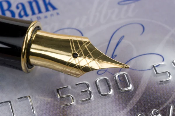 Caneta-tinteiro de bico de ouro clássico contra cartão de crédito — Fotografia de Stock