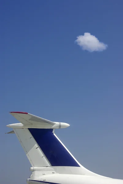 Avión civil sobre un cielo azul profundo con alguna nube — Foto de Stock