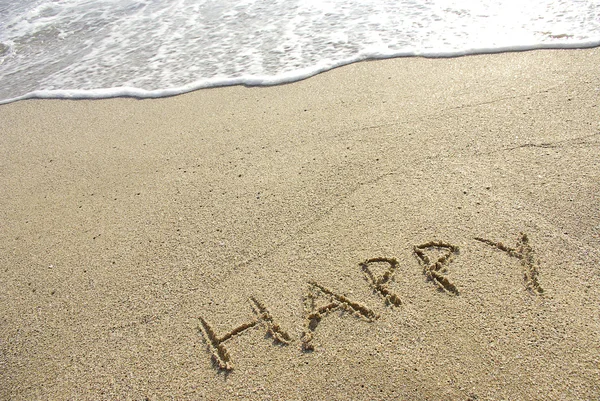 Feliz desenhado na areia com seafoam e onda — Fotografia de Stock