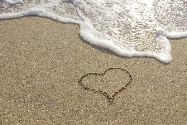 Καρδιά που στην άμμο με seafoam και το κύμα — Φωτογραφία Αρχείου