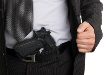 Man in suit showing gun tucked in pants clipart