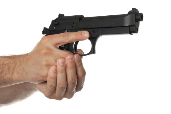 Two hands holding a gun with finger off the trigger — Stock Photo, Image