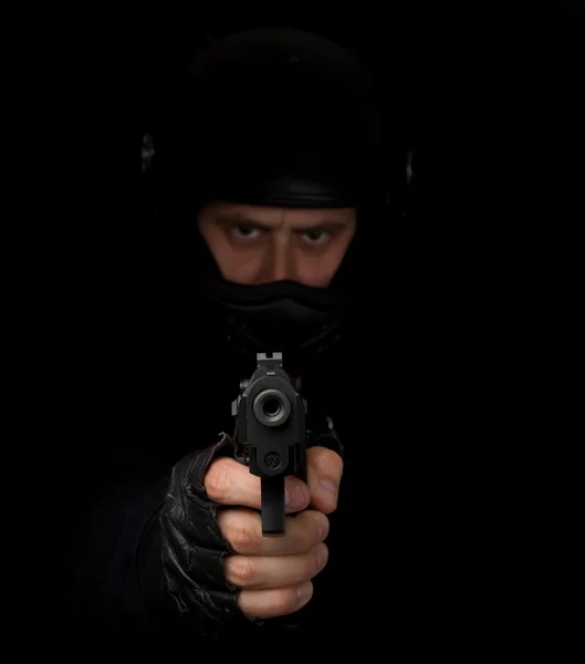 Armed assassin with motorcycle helmet aiming into the camera — Stock Photo, Image