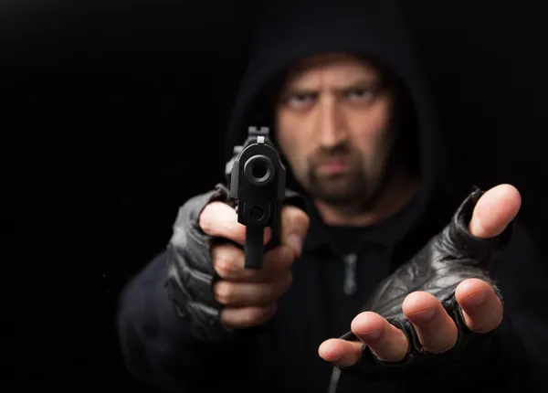 Robber with gun holding out hand — Stock Photo, Image