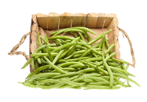 Banda zelené fazolky z dřevěné koše — Stock fotografie