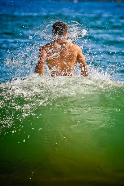 stock image Caucasian man from behind shaking water off in the ocean