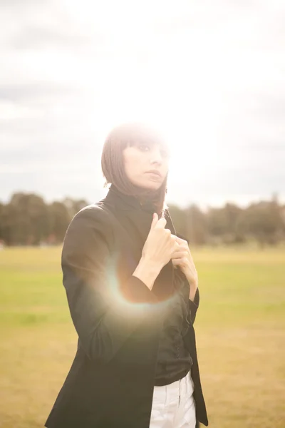 Ung kaukasisk kvinde i en park med sol skinnende - Stock-foto