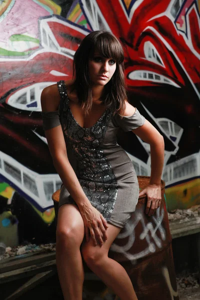 Unga kaukasiska kvinna framför graffiti vägg — Stockfoto
