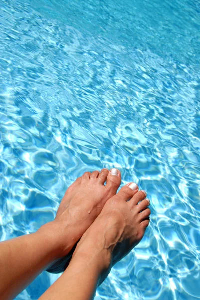 Pies sobre la piscina espumosa — Foto de Stock