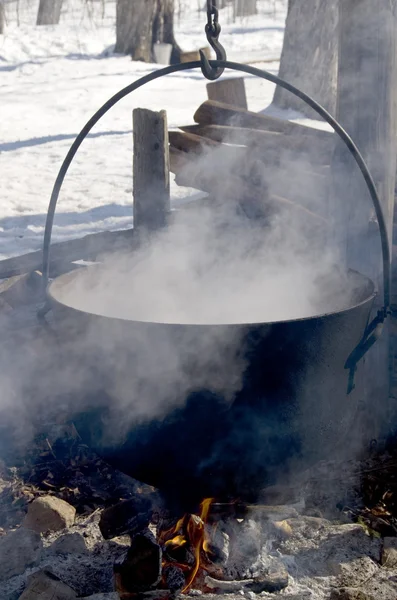 Maneira tradicional de fazer xarope de bordo fervendo a seiva em um caldeirão para concentrar o açúcar . — Fotografia de Stock