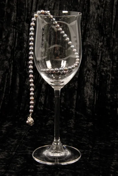 Uma série de pérolas penduradas em um copo de vinho de cristal — Fotografia de Stock