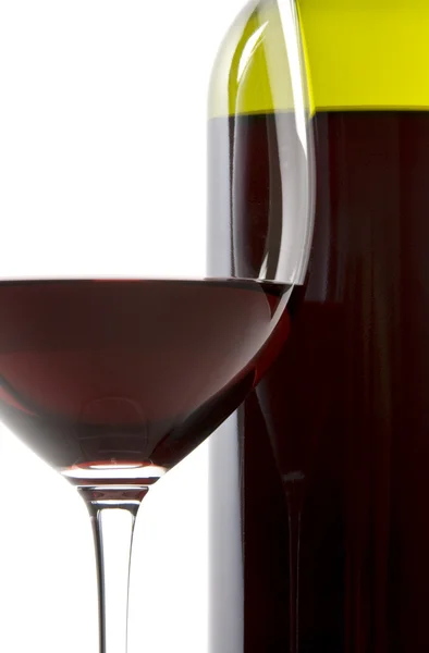 Glas rött vin bredvid en flaska — Stockfoto