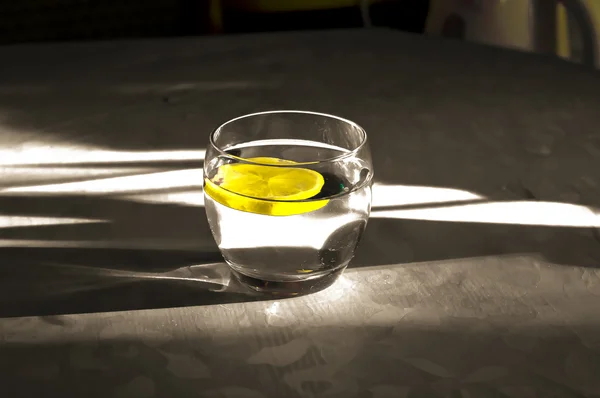 stock image Water with lemon in glass.