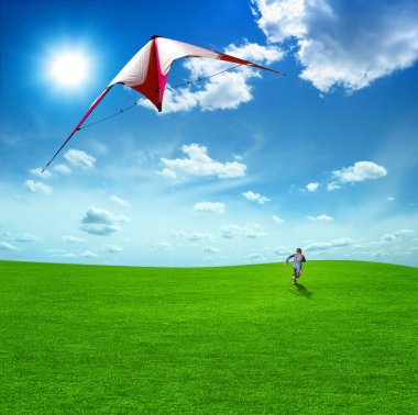 Boy playing kite against the beautiful sky and clouds. clipart