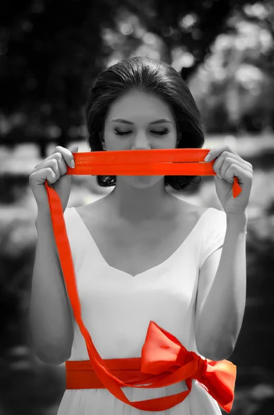 Retrato de una chica con cinta roja cubriéndose la boca — Foto de Stock