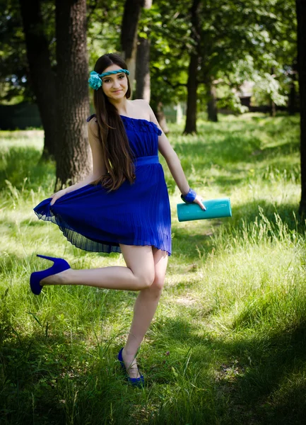 穿着蓝色的衣服，躺在草地上的美丽 — 图库照片