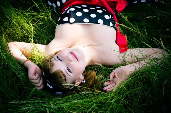 Fille se trouve dans l'herbe verte fraîche épaisse — Photo
