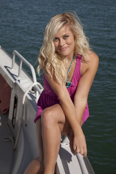 Rosa klänning sitta sida båt leende — Stockfoto