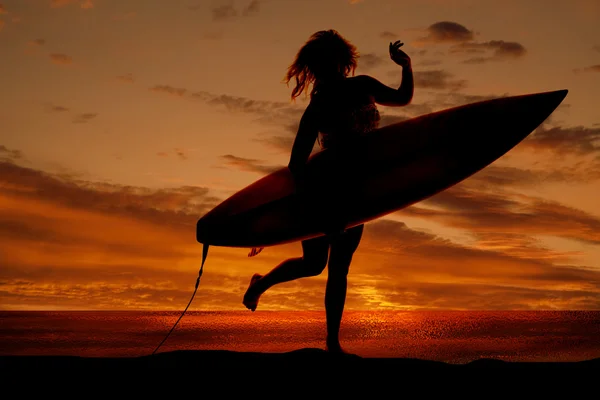 Vrouw uitvoeren surf board zonsondergang — Stockfoto