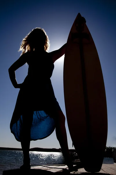 Frau Silhouette stehen neben Surfbrett — Stockfoto