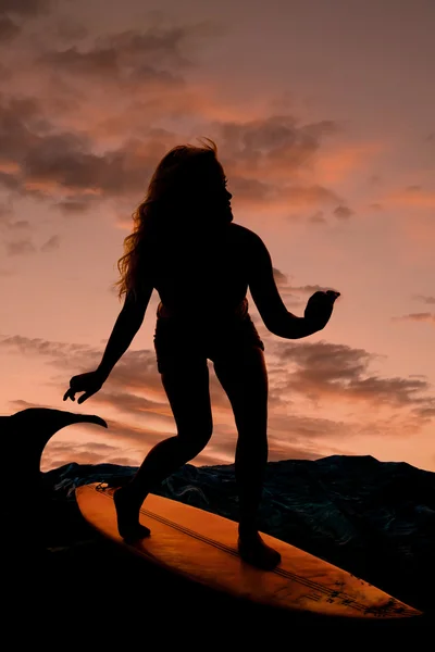 Vrouw surfen in zonsondergang — Stockfoto