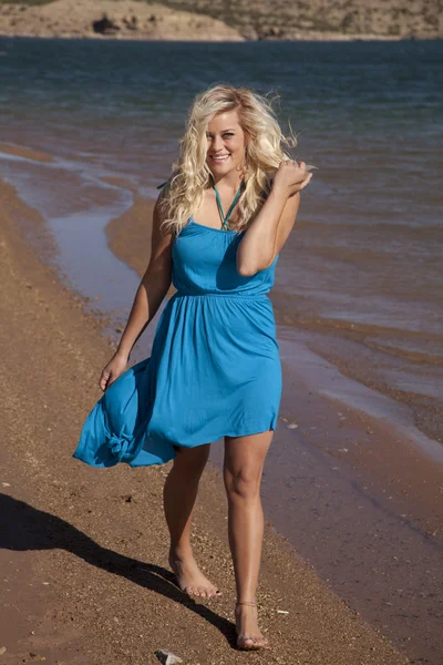 Женщина ходить пляж голубое платье — стоковое фото