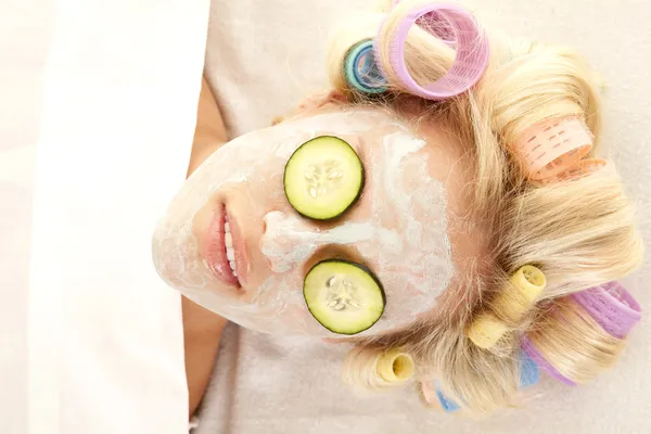 Vrouw masker komkommers — Stockfoto