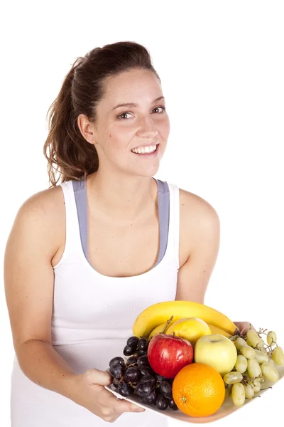 Vrouw in witte tank boven houden vruchten plaat — Stockfoto